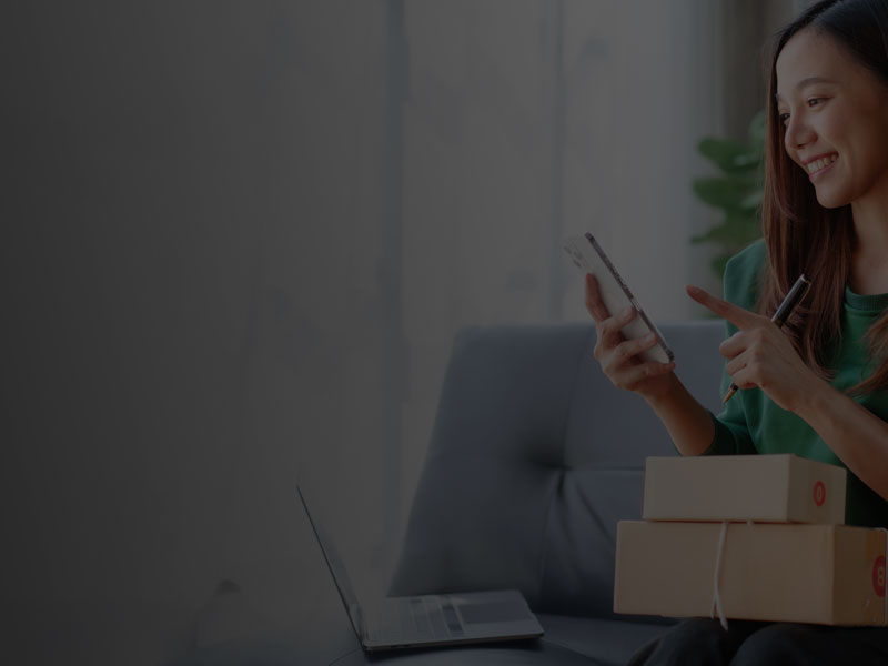 Shop Hosting wird durch eine Shop Betreiberin genutzt. Sie schau auf ihr Handy.