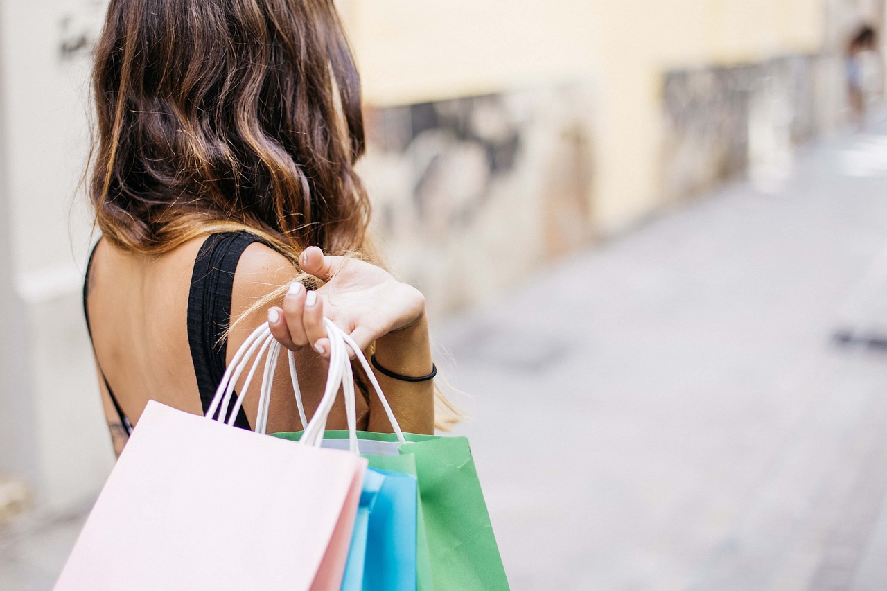 Shopping: Frau mit mehreren EInkaufstüten auf der Straße