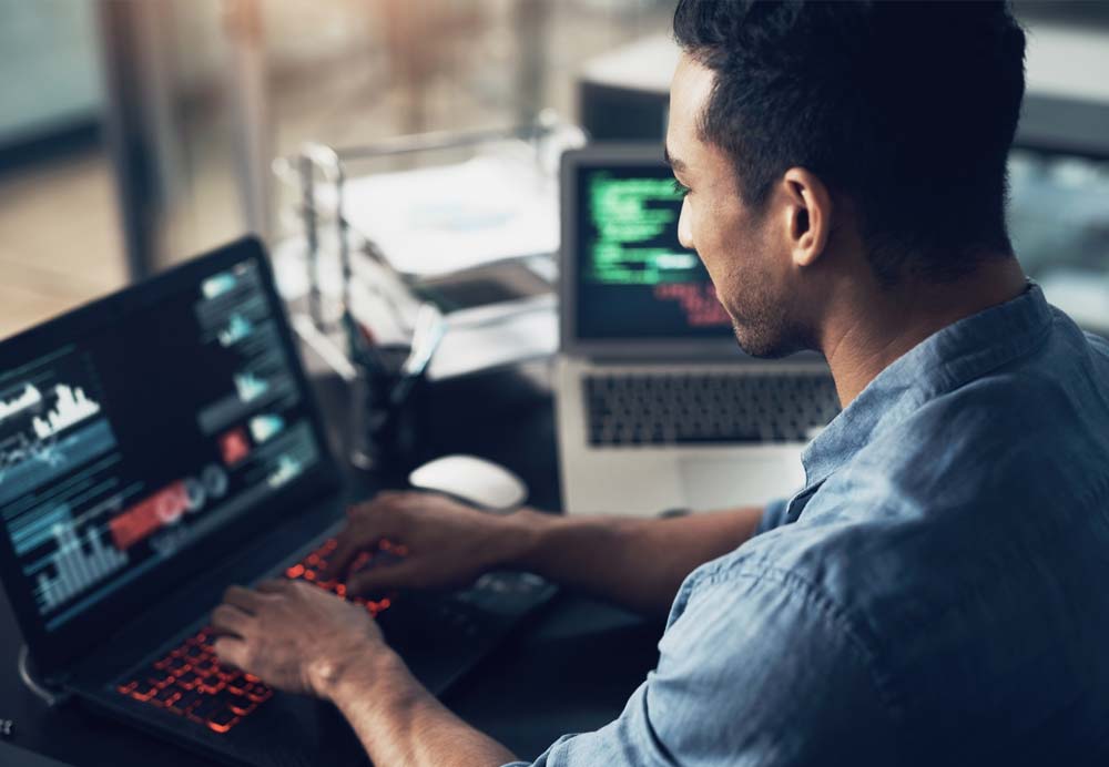 A businessman works on the computer and manages his servers, which are located in the Keyweb data center